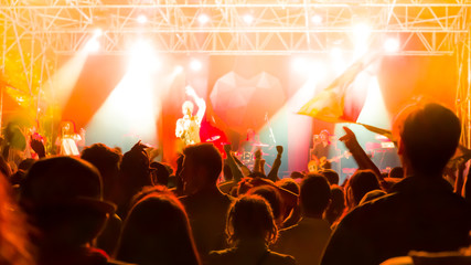 Fototapeta na wymiar Concert crowd against bright stage lights