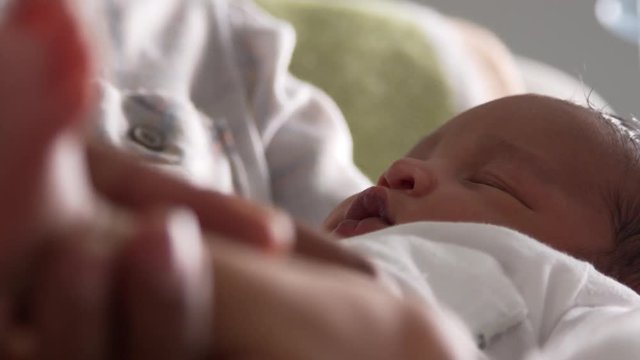 Close Up Of Parents Cuddling Newborn Baby Son In Nursery