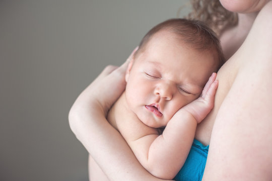Sweet newborn baby sleeping on his mother's chest