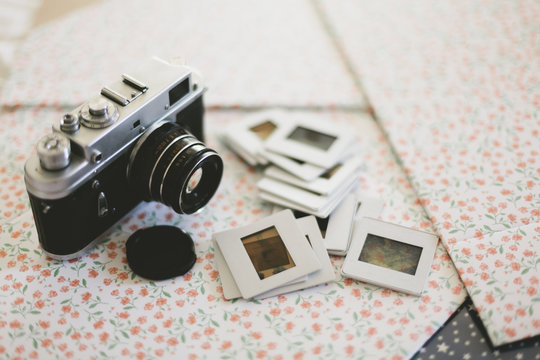 Vintage reflex camera close to bunch of old diapositives