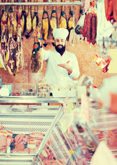 Ordinary man seller showing jamon