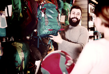 Fototapeta premium Man shows the girl a blue backpack