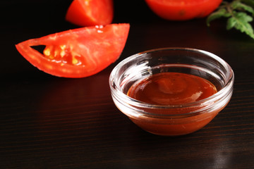 Ketchup on a black background and tomato basil