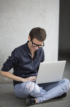 young woman using a laptop on the street
