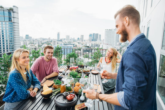 Group of Friends Eating Together on a Balcony