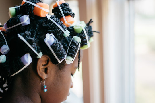 Black girl with curlers in her hair