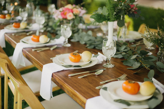 Botanical greenery wedding table setting in tent with string lights