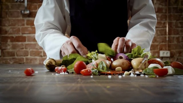 Cookery lessons. A chef preparing products for making a dish in the kitchen of a trendy restaurant. 4K
