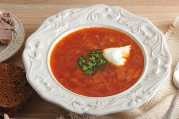 soup in a bowl with dill, sour cream and black bread