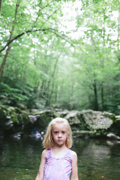 young girl alone in a mountain stream