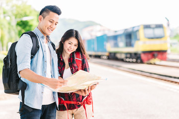 Happy young Asian couple traveler holding a map at train station ready for vacation © interstid