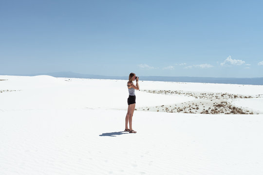 Woman taking photos in desert