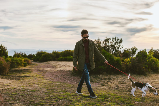 Man walking with his beagle dog on the mountain.