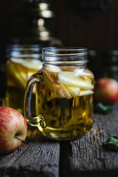 A Refreshing Jug Of Apple Cider On Wood Planks.