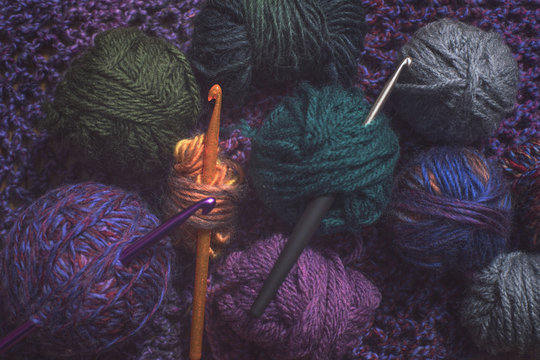 Close up of colourful left-over wool and crochet hooks....