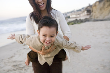 Mother Holding Son in Flying Position