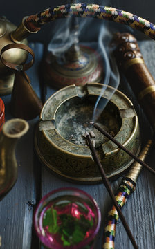 Incense sticks burning and smoking in a still life setting.