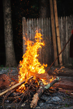 A campfire outdoors in the evening.