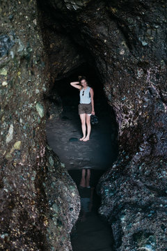 young female hiking and exploring rock formations and caves in northwest usa