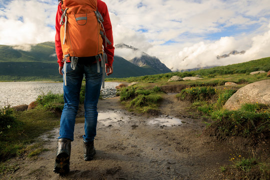 young backpacking woman hiking in mountains