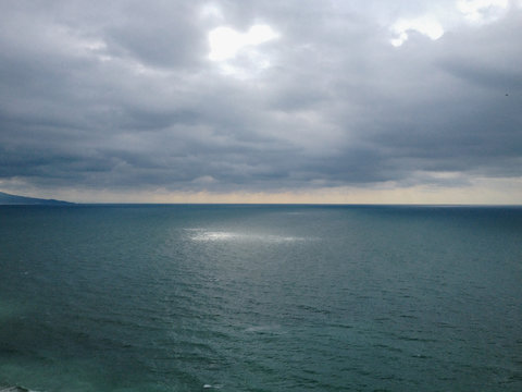 view. Beam of sunlight shines through the clouds onto the oceans service