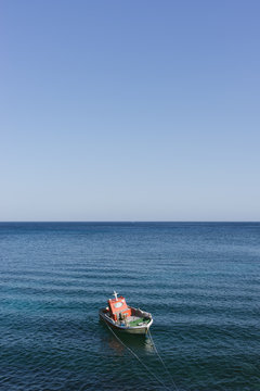 A boat in calm blue mediterranean sea against sky