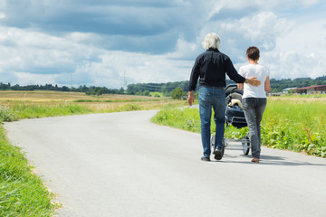 Grandparents Going For A Walk With Granchild