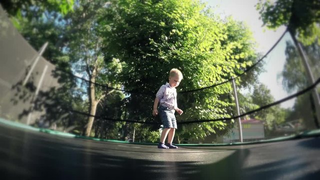 Joyful, cheerful cute child, funny baby kid boy jumping on a trampoline. Recreation and entertainment. Growth and development of the child. Health and active recreation, childhood memories