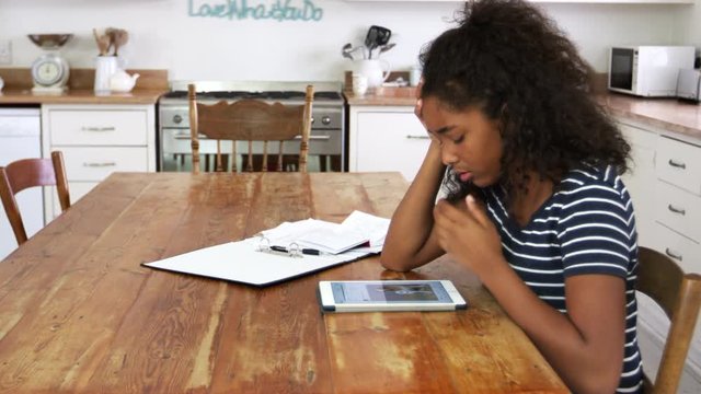 Stressed Teenage Girl With Digital Tablet Revising For Exam