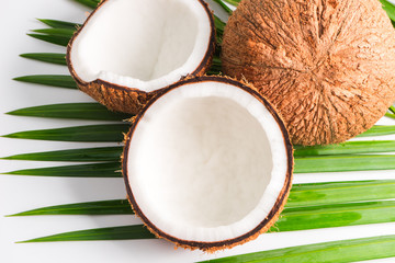 Coconut with half and leaves on white background