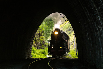 Old steam locomotive enters the tunnel on the Circum-Baikal Railway