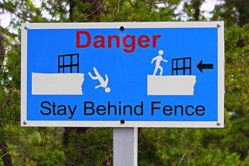 Fototapeta premium Closeup of a danger stay behind fence sign