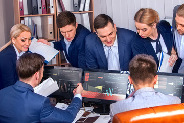 Obraz premium Business people office life of team people working with papers sitting table. Cabinets with folders and jalousie background. Schemas and diagrams on computer monitor. Diagrams on a black background.