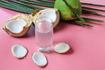 Fresh  coconut water in glass Ready to drink with leaf on  pink background, summer and healthy concept. 