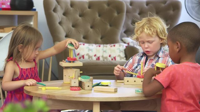 Montessori School Pupils Work At Desk With Wooden Building Set
