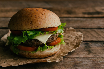 Homemade hamburger or sandwich on brown paper. Delicious sandwich hamburger with meat or pork ham cheese and fresh vegetable. Hamburger or sandwich is the popular fast food for brunch or lunch.