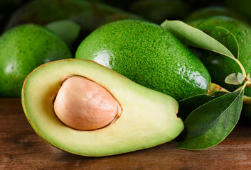 Closeup view of fresh ripe green avocado on wooden table