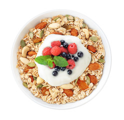 Muesli with fresh berries, nuts and yogurt in a bowl isolated on white background.