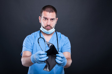 Doctor or medic showing empty wallet looking sad