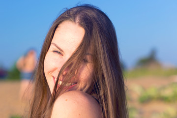 An embarrassed young woman covers her face with her hair