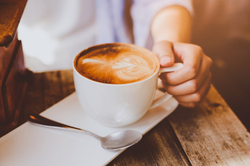 female hands holding Latte art, coffee cup.