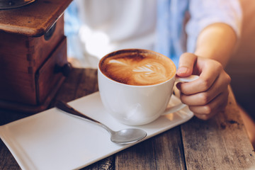 female hands holding Latte art, coffee cup.