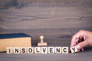 insolvency. Wooden letters on dark background. Office desk