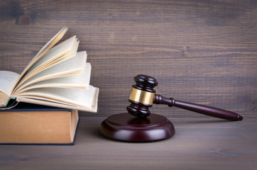 Wooden gavel and books in background. Law and justice concept.