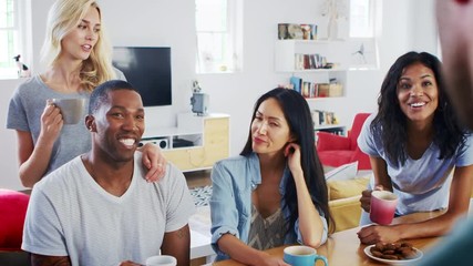 Group Of Young Friends Chatting And Drinking Coffee In Kitchen