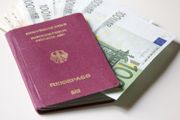German international traveling passport and euro money.