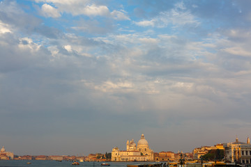 Basilica di Santa Maria della Salute at orange colors reflected on the water surface, Venice, Italy.