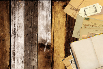 Old book and vintage postcards on old wooden planks
