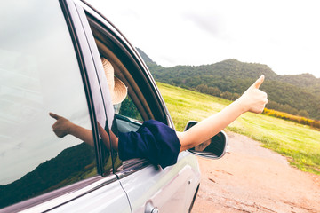 Woman hand on the car relaxing and happy traveler with mountain background
