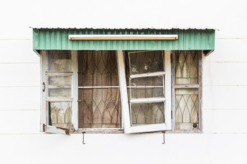 Old broken wooden windows on white concrete wall.